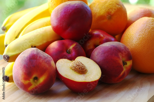 ripe peaches. bananas  and citrus fruits in table