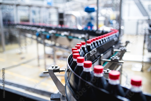 Wallpaper Mural Bottling factory - Black juice bottling line for processing and bottling juice into bottles. Selective focus.  Torontodigital.ca
