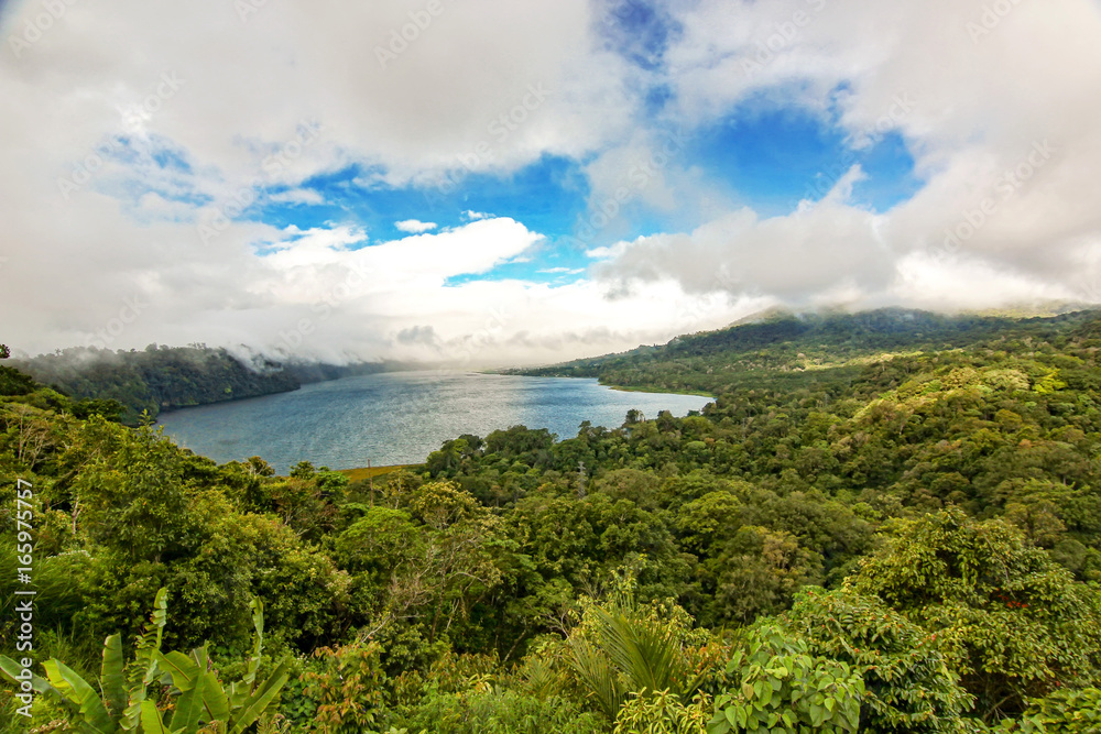 Lake in the forest and mountain with cloudy sky background