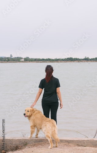 woman and golden dog on riverside