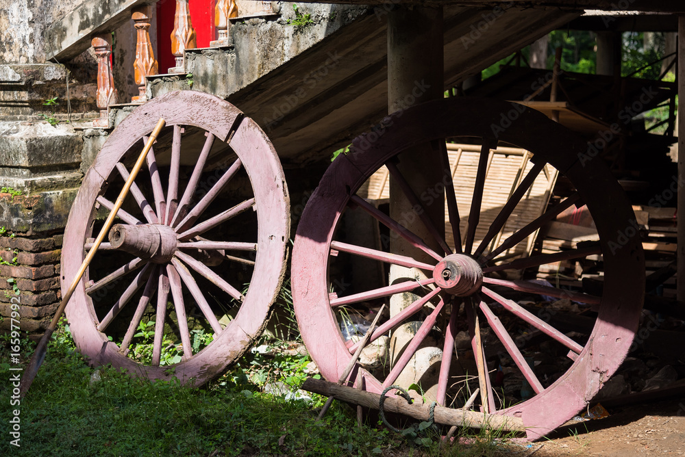 Old wooden wheels of the cart in temple, Thailand.