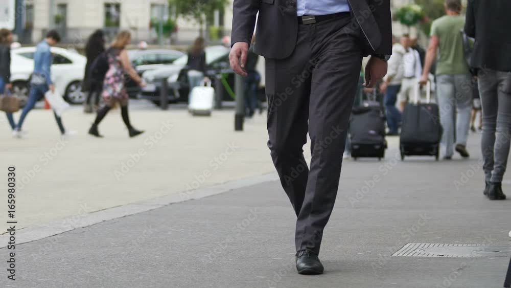 Businessman walking in the street near train station, tourism, slow-motion Businessman walking in the street near train station, tourism, slow-motion