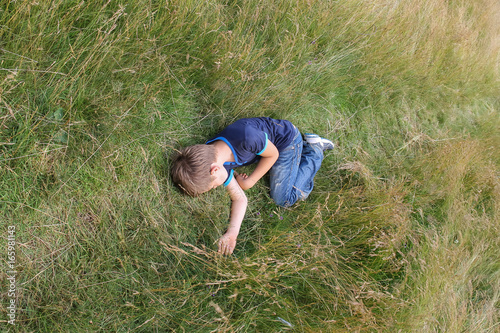 Handsome boy sleeping on meadow grass photo