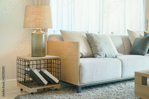 Table lamp next to comfy sofa in modern style living room