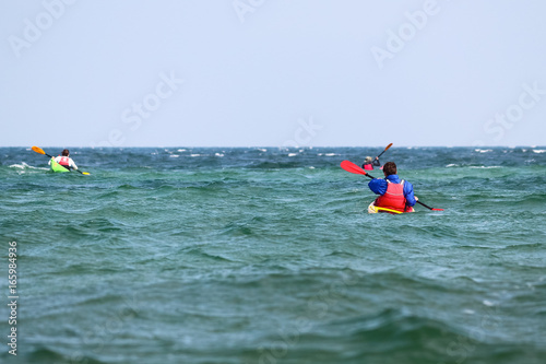Kayak surfer over the crest of a wave in rough turquoise Black Sea