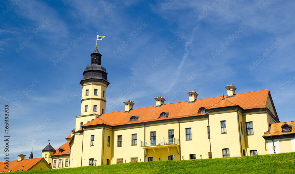 Ancient castle standing on a hill with green grass under deep blue sky