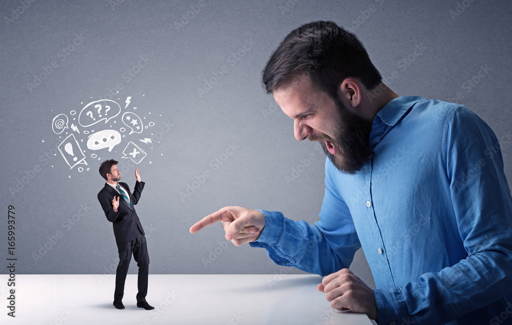 Young businessman fighting with miniature businessman Young businessman fighting with miniature businessman