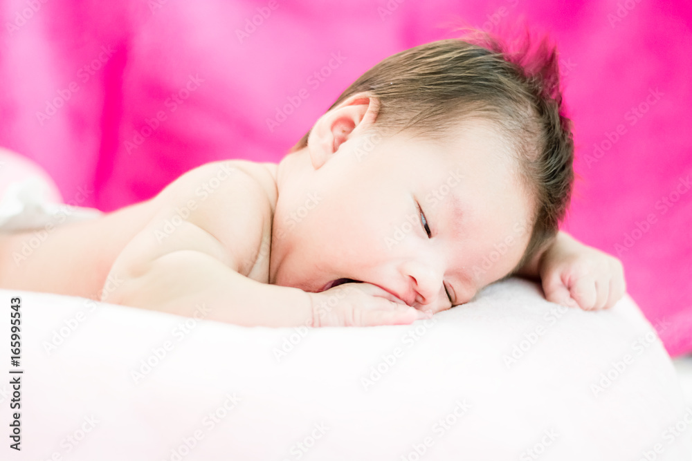 Portrait of a little adorable infant baby girl yawning before sleep on the bed indoors Portrait of a little adorable infant baby girl yawning before sleep on the bed indoors