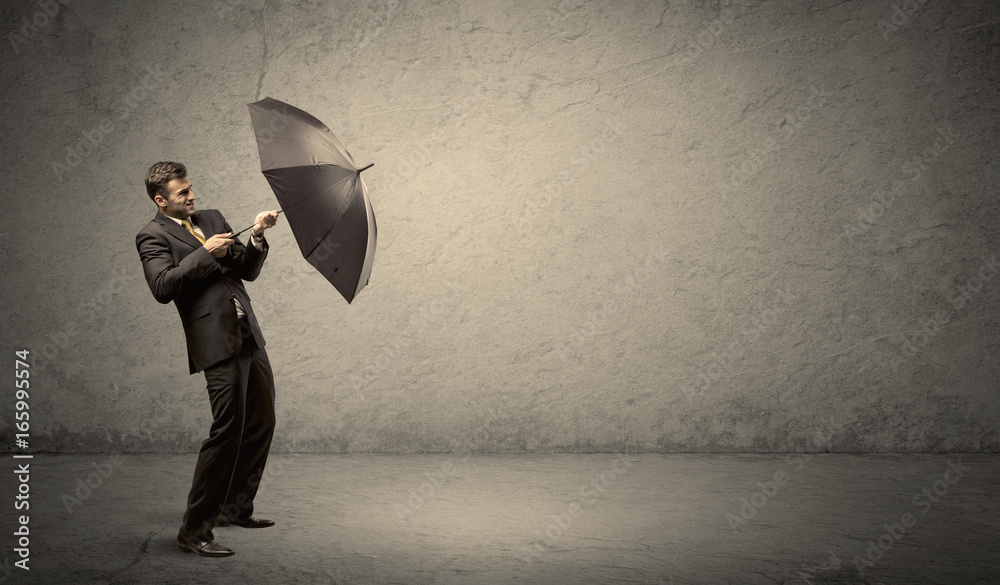 Handsome business man holding umbrella with copy space background Stock