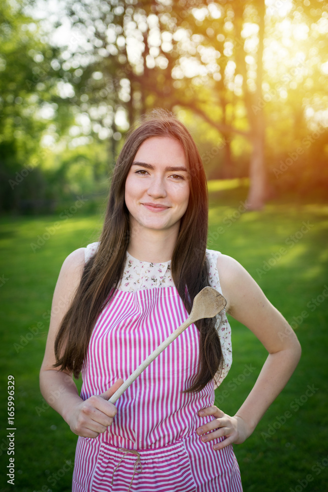 Young housewife with spoon in a natural environment Young housewife with spoon in a natural environment