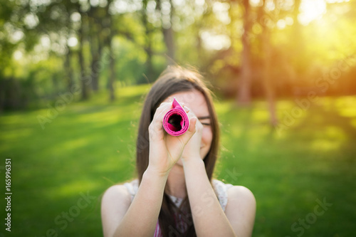 Young woman is looking through a rolled table-cloth