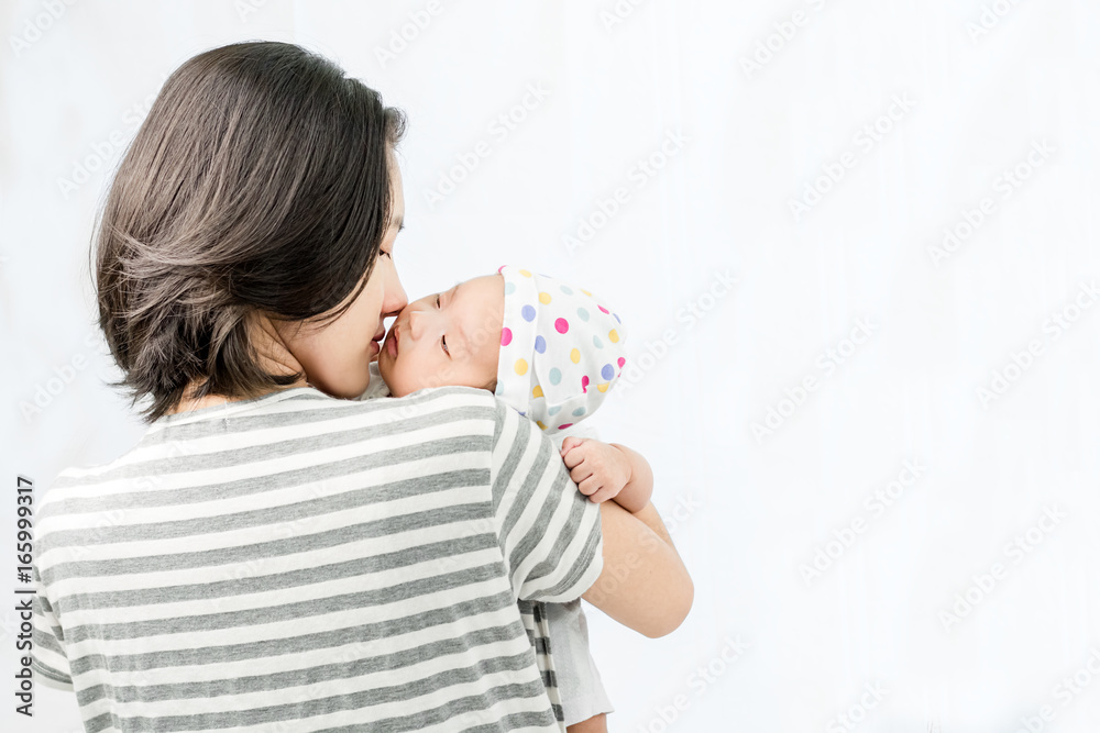 Portrait of a mother hugging her baby in hands and looking to her baby with love. Portrait of a mother hugging her baby in hands and looking to her baby with love.