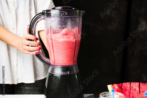 Female making watermelon smoothie with blender