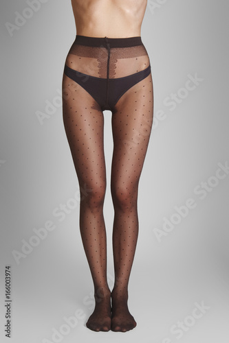 Long slim female legs in transparent tights with a classic polka dot pattern