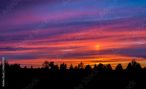 Colorful sunset with clouds and trees