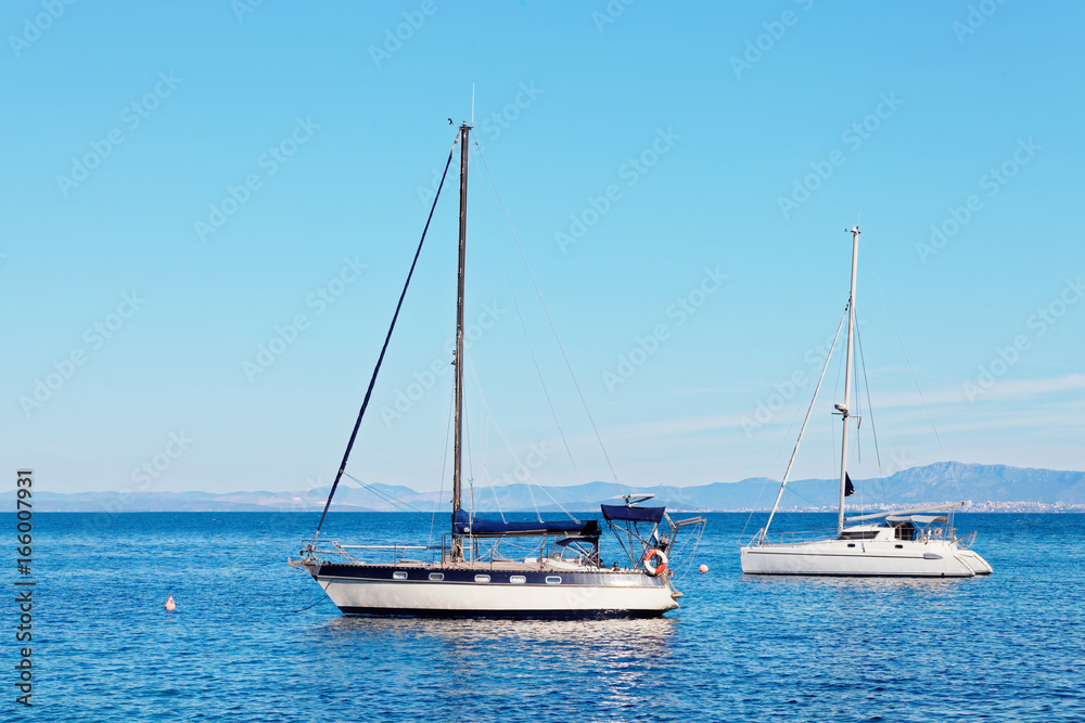 Yatchs moored in the harbor near a small town - Croatia, island Brac