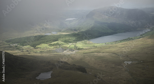 Landscape view of Llyn Cwellyn and Moel Cynghorion in Snowdonia shrouded in fog and cloud