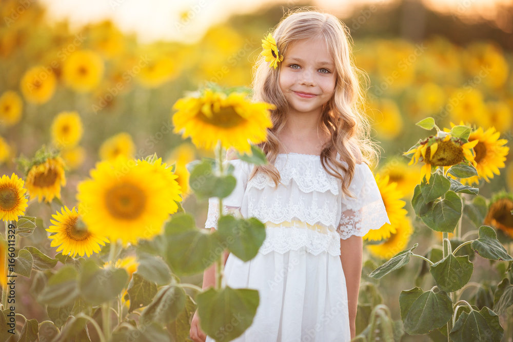 Beautiful child girl in yellow garden of sunflowers Beautiful child girl in yellow garden of sunflowers