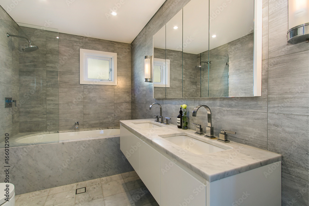 A modern bathroom with a shower area and a bathtub including a wall mirror A modern bathroom with a shower area and a bathtub including a wall mirror