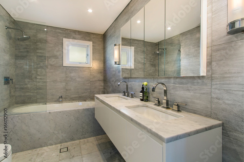 A modern bathroom with a shower area and a bathtub including a wall mirror