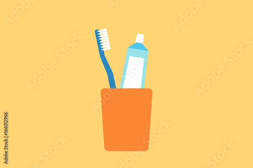 toothbrush and toothpaste in glass