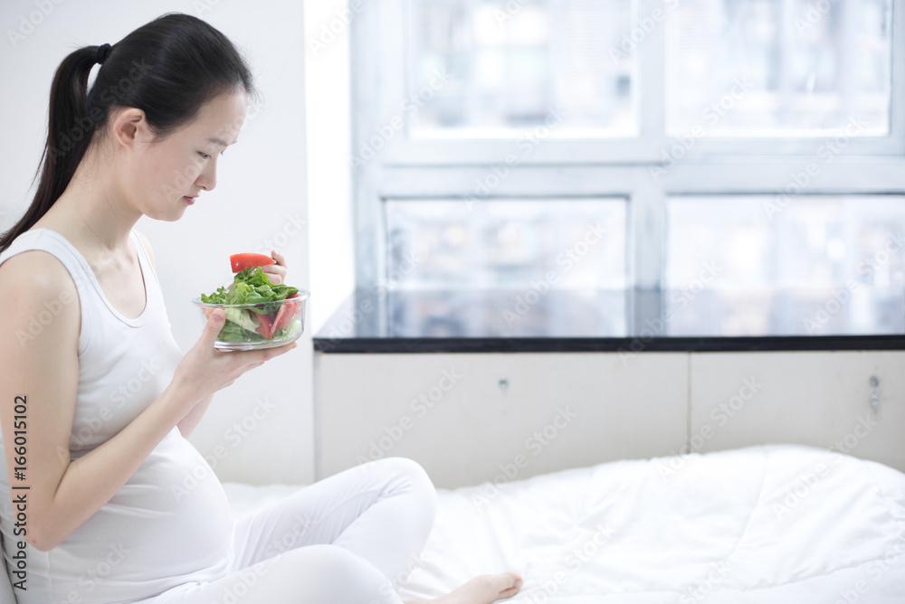 healthy nutrition and pregnancy. pregnant woman's belly and vegetable salad healthy nutrition and pregnancy. pregnant woman's belly and vegetable salad