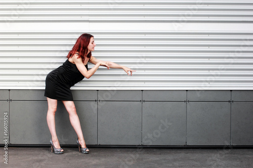 Sports brunette with a beautiful body in black dress on light snow background. Copy space. © StarlingRu