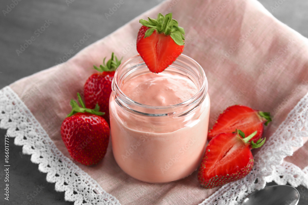 Composition with fresh homemade yogurt and strawberries on grey background Composition with fresh homemade yogurt and strawberries on grey background