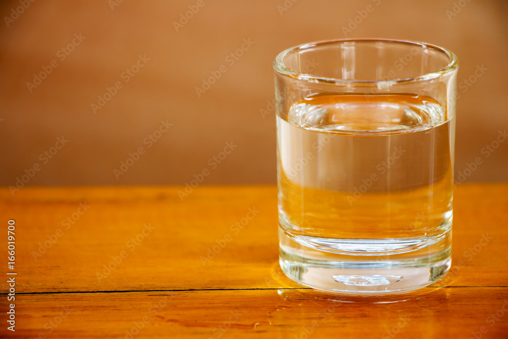 Drinking water in a glass on a wooden table Drinking water in a glass on a wooden table