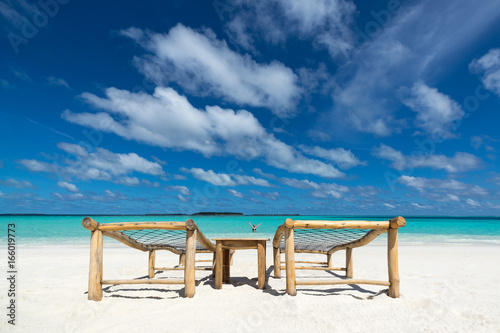 Fototapeta Naklejka Na Ścianę i Meble -  Empty wooden beach chairs on the tropical beach, vacation. Traveler dreams concept