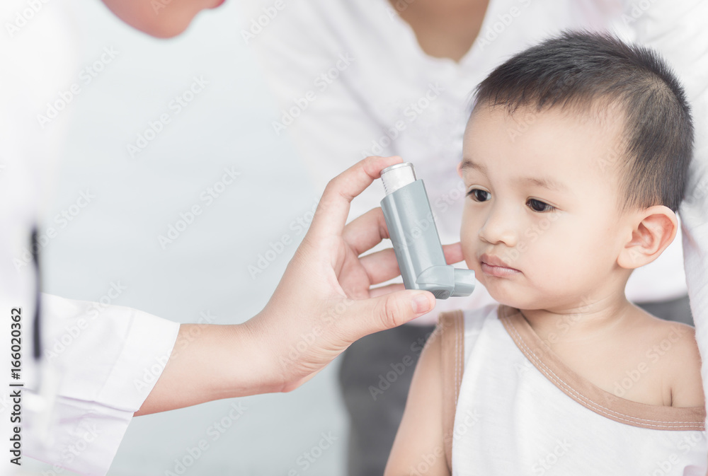 Selective focus Pediatrician advise a woman using Asthma inhaler for her son.
