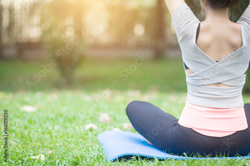 Yoga in the park, outdoor with effect light, healthy woman.  Concept of healthy lifestyle and relaxation.