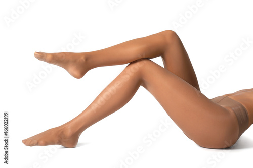 Legs of beautiful young woman in tights on white background photo