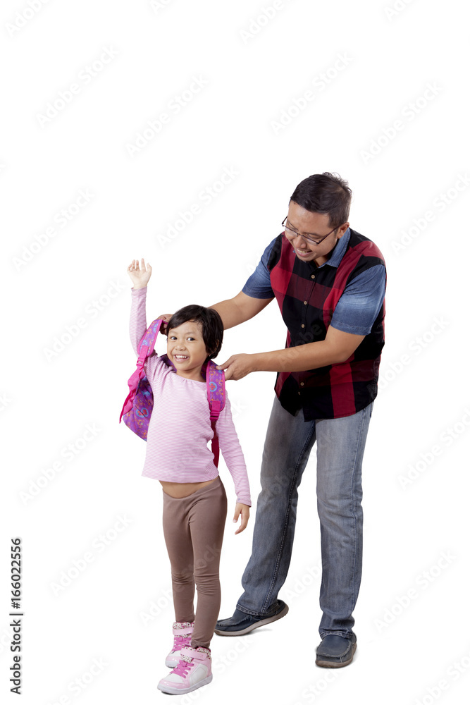 Father helps his child to wear backpack Father helps his child to wear backpack