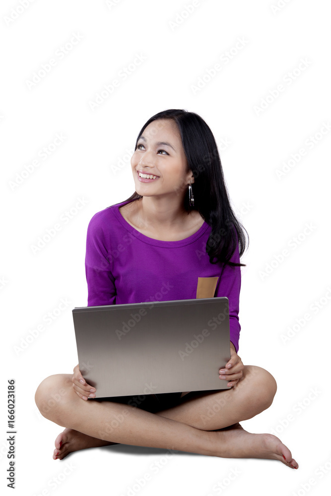 Girl with laptop sitting in studio Girl with laptop sitting in studio