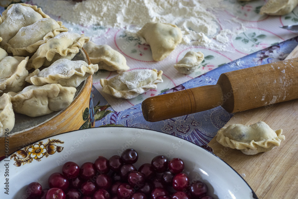 Fototapeta premium Cooking at home dumplings with cherries