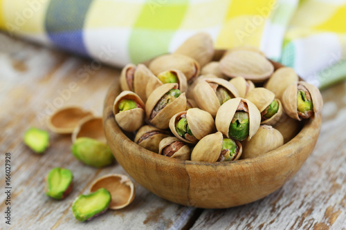 Obraz na płótnie Healthy snack: pistachio nuts in wooden bowl, closeup
w salonie