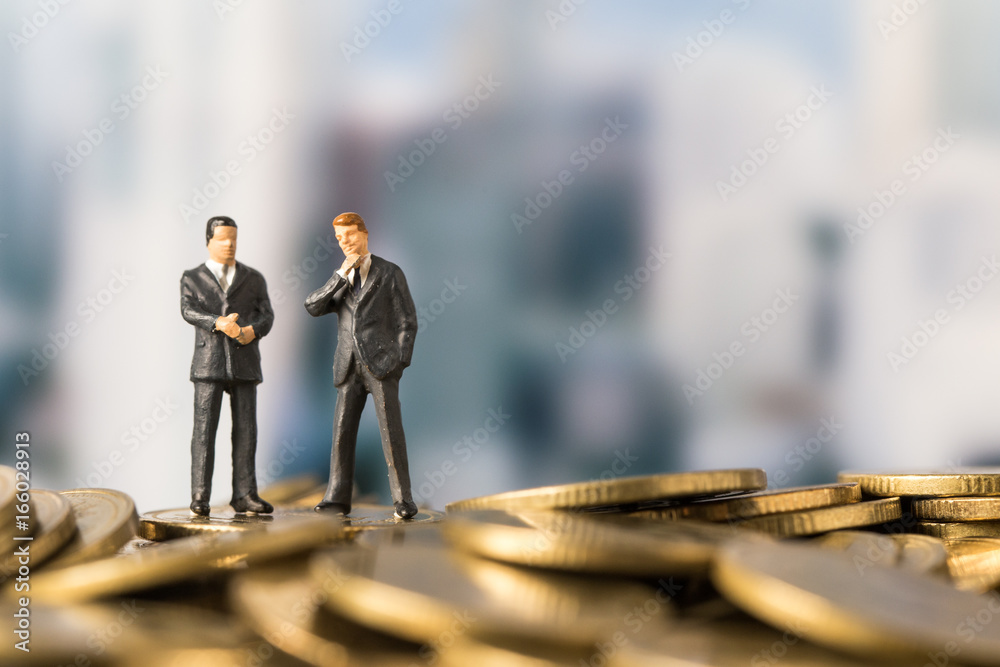 miniature model of investor standing on coin with city background. Business successful concept. miniature model of investor standing on coin with city background. Business successful concept.
