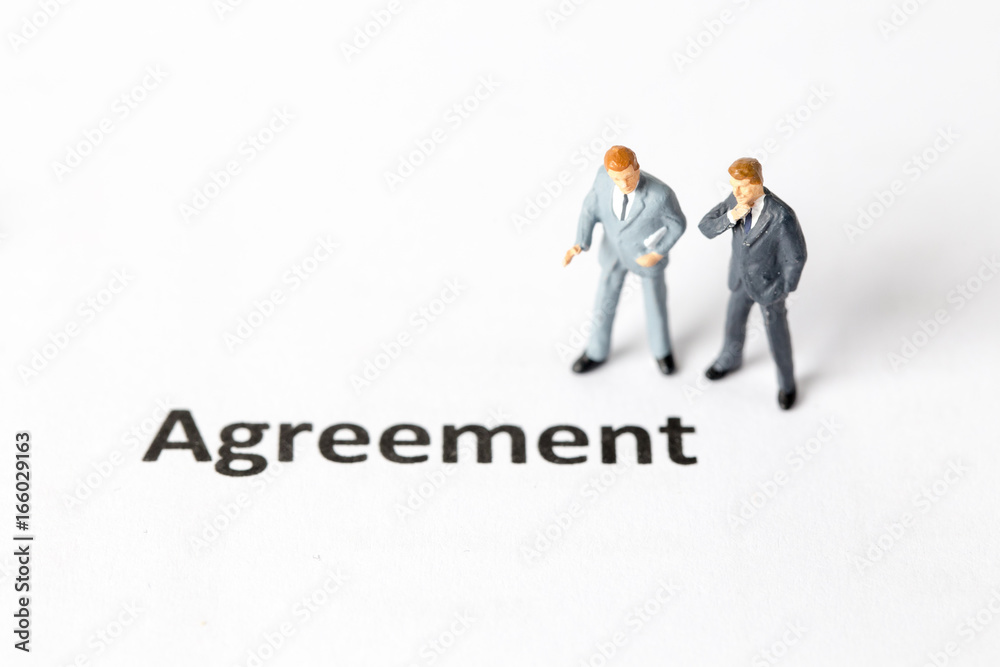 Miniature model of businessman standing with agreenent wording. People with agreement concept. Miniature model of businessman standing with agreenent wording. People with agreement concept.