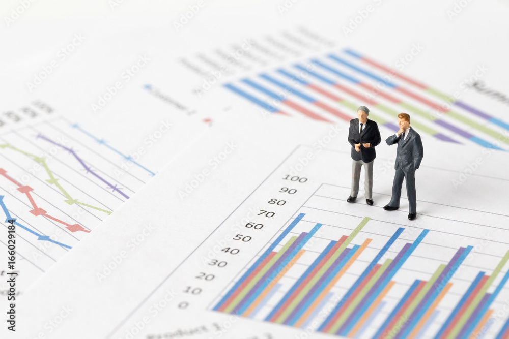 Miniature model of businessman thinking with project for presenting investment concept on graph. Miniature model of businessman thinking with project for presenting investment concept on graph.