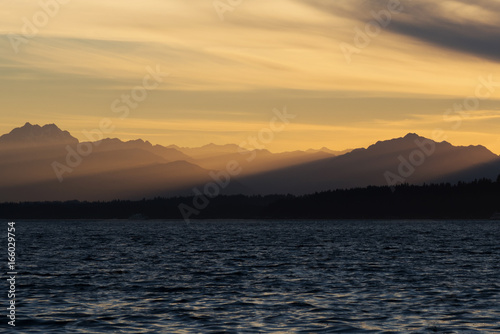 Rays of sunlight cascading through mountain peaks at sunset