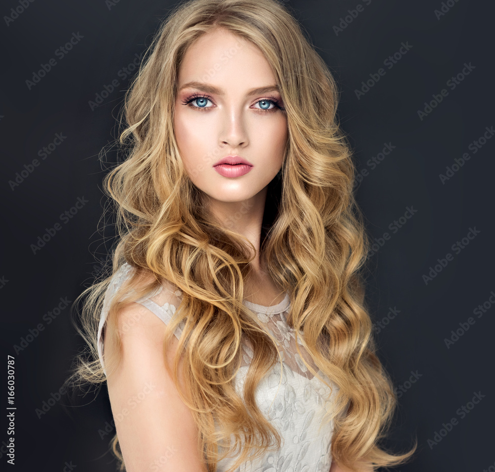 Blonde fashion girl with long and shiny curly hair . Beautiful model in light blue dress with wavy hairstyle . Stock Photo | Adobe Stock Blonde fashion girl with long and shiny curly hair . Beautiful model in light blue dress with wavy hairstyle . Stock Photo | Adobe Stock