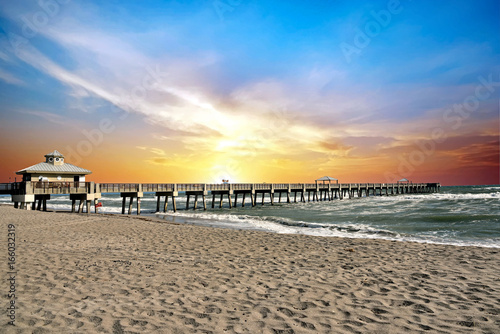 The Juno Beach Fishing Pier, Florida at sunrise on a windy summer day. photo
