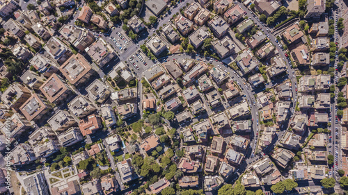 Vista aerea ortogonale di una parte del quartiere Monteverde a Roma. Tra le strade strette e i palazzi si vedono alberi e tanto verde mentre sugli edifici antenne e parabole.