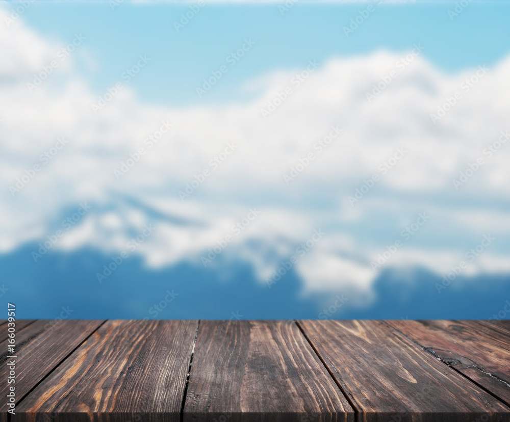 image of wooden table in front of abstract blurred background of mountain. can be used for display or montage your products. Mock up for display of product.