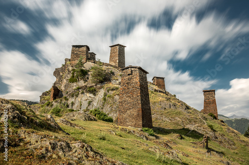 Medieval fortress Keselo in village Omalo in Tusheti, Georgia. Stone towers with blue sky and clouds taken by long exposure. photo