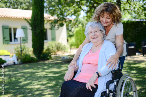cheerful mature woman visiting her mother elderly senior female walk in retirement house hospital garden