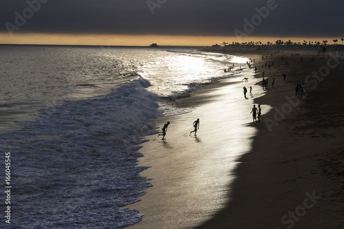 Fototapeta Naklejka Na Ścianę i Meble -  Beach people playing silhouette at sunset