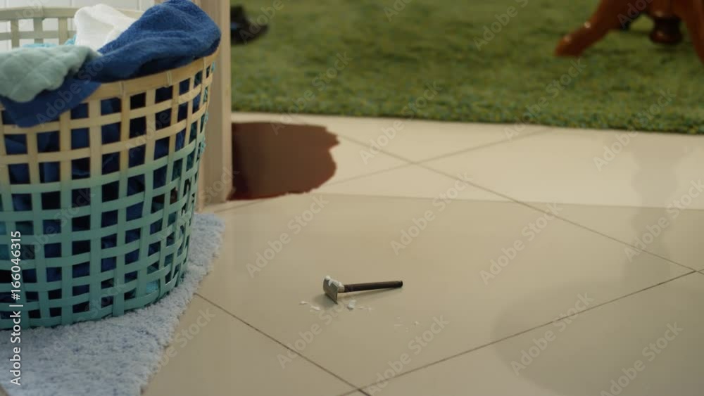 Stock Suicide and self harm concept with a bloody razor dropped in a pool of red blood in the bathroom sink with a hand reaching for it. Pool of blood on the floor next to a razor for shaving | Adobe Stock