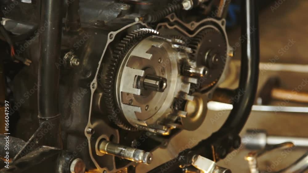 A hand of motorcycle mechanic assembling clutch assembly using light. A hand of motorcycle mechanic assembling clutch assembly using light.
